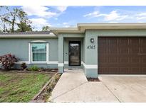 Charming home exterior featuring an attached garage and well-maintained landscaping at 4565 Eldron Ave, North Port, FL 34286