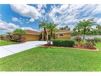 Charming single-story home featuring a well-manicured lawn and lush tropical landscaping at 5359 90Th Avenue E Cir, Parrish, FL 34219