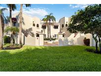 Inviting beige condo building with lush green lawn and tropical landscaping at 6101 34Th W St # 11C, Bradenton, FL 34210