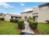 Inviting home featuring a manicured lawn, symmetrical shrubs and a well-maintained facade at 6860 Whitman Ct # 32B, Sarasota, FL 34243
