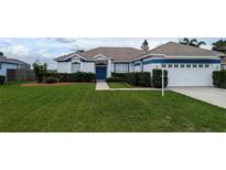 Charming single-story home with blue and white trim, well-manicured lawn, and a two-car garage at 9402 71St E Ave, Palmetto, FL 34221