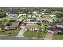 An aerial view of a single-story home featuring a well-manicured lawn and a beige tile roof at 107 Van Dyck Dr, Nokomis, FL 34275