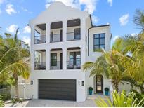 Stunning three-story modern home with black framed balconies and a two-car garage at 109 Palmetto Ave, Anna Maria, FL 34216