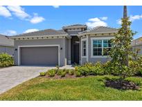 Beautiful single-story home featuring manicured lawn and a neutral gray color palette at 17632 Santorini Ct, Venice, FL 34293