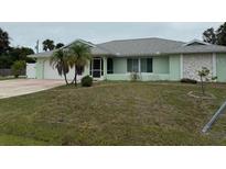 Charming single story home with a well-maintained lawn and mature landscaping at 20170 Tralee Dr, Port Charlotte, FL 33952