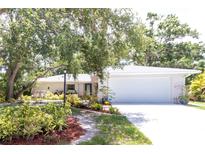 Charming one-story home featuring a two-car garage, landscaped yard, and mature trees at 2515 Huntington Ave, Sarasota, FL 34232