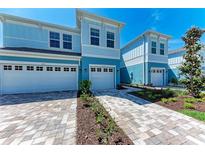 Charming light blue townhouses featuring well-manicured landscaping and brick paver driveways at 317 Via Tuscany Ave, Sarasota, FL 34243