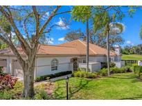 Charming single-story home featuring a tile roof, mature landscaping, and a welcoming entrance gate at 3881 Chatsworth Greene Ct # 20, Sarasota, FL 34235