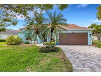 Charming single-story home features a well-manicured lawn, brick driveway, and lush tropical landscaping at 4120 51St W Dr, Bradenton, FL 34210