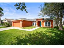 Charming one story home with a blue front door, orange exterior paint and well-maintained lawn at 4194 Banbury Cir, Parrish, FL 34219