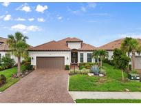 Beautiful single-story home with a red tile roof, brick driveway, lush landscaping, and a two-car garage at 4720 Arpino Ct, Bradenton, FL 34211