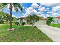 Charming single-story home featuring a lush lawn, mature landscaping, and a two-car garage at 4811 14Th E Ave, Bradenton, FL 34208