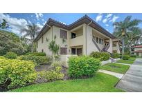 Inviting two-story condo with lush landscaping, a terracotta roof and vibrant tropical surroundings at 5255 Lake Village Dr # 40, Sarasota, FL 34235