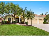 Inviting home featuring a tile roof, a well-manicured lawn, palm trees, and a three-car garage at 6811 Honeysuckle Trl, Lakewood Ranch, FL 34202