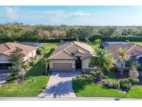 Beautiful single-Gathering home featuring tile roof, brick driveway and tropical landscaping at 7140 Marsh View Ter, Bradenton, FL 34212