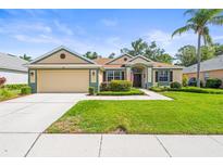 Charming single-story home featuring a lush green lawn, two-car garage, and well-maintained landscaping at 743 Stonecrest Dr, Sarasota, FL 34232