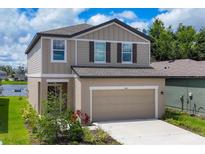 Charming two-story home featuring a two-car garage, neutral color palette, and well-manicured landscaping at 10611 Ladybug Cv, Parrish, FL 34219