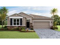 Charming single-story home features a stone veneer, a two-car garage and a well-manicured lawn at 18228 Beach Ranch Ter, Lakewood Ranch, FL 34211