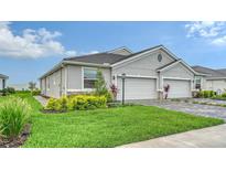 Charming home with a two-car garage, lush green lawn, and well-maintained landscaping at 18324 Cropside Trl, Lakewood Ranch, FL 34211