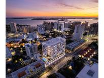 Stunning aerial view of a modern, luxurious condo building overlooking the city at sunset at 290 Cocoanut Ave # 8B, Sarasota, FL 34236