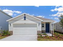Charming single Gathering home featuring a two car garage, stone accents and blue door at 3218 Bitterroot Ln, Lakewood Ranch, FL 34211