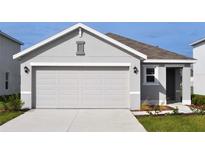 Two car garage door and driveway to a one-story home with gray stucco exterior under a bright blue sky at 3278 Rock Sound St, Bradenton, FL 34208