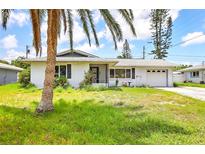 Charming single-story home featuring a lush front yard and an attached one car garage at 3303 Cambridge W Dr, Bradenton, FL 34205