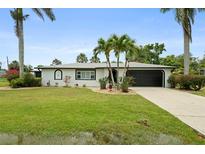 Charming single-story home boasts a well-manicured lawn, mature trees, and a two-car garage at 3631 Palm Dr, Punta Gorda, FL 33950