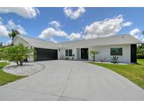 A beautiful, one-story home with a gray driveway and a two-car garage at 3634 Torrey Pines Way Way, Sarasota, FL 34238