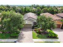 Inviting single-Gathering home featuring a well-manicured lawn and brick driveway at 5117 Serata Dr, Bradenton, FL 34211