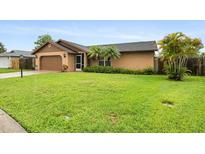 Exterior view of a home features a lush lawn, mature landscaping and an attached garage at 5433 81St Avenue E Cir, Palmetto, FL 34221