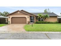 Charming single-story home featuring a two-car garage, mature landscaping, and a well-manicured lawn at 5433 81St Avenue E Cir, Palmetto, FL 34221