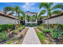 Beautiful condo complex featuring lush landscaping and a welcoming walkway to the units at 5695 Palmer Cir # 203, Bradenton, FL 34211