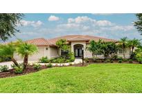 Beautiful front yard with lush green grass, palm trees, and a well-maintained garden leading to the charming home at 5897 Carriage Dr, Sarasota, FL 34243