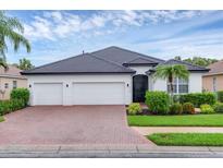 Well-maintained single-story home with a paver driveway, three-car garage, and neatly landscaped front yard at 7119 67Th E Ter, Bradenton, FL 34203