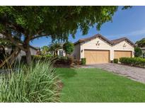 Charming home with a well-manicured lawn and a two-car garage, showcasing its inviting curb appeal at 8291 Varenna Dr, Sarasota, FL 34231
