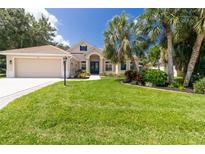 Charming single-story home with a well-manicured lawn, lush landscaping, and an attached two-car garage at 866 Oak Briar Ln, Osprey, FL 34229
