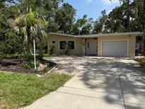 Charming single-story home with a well-maintained lawn, stone accents, and mature trees at 2311 W 52Nd Ave Drive, Bradenton, FL 34207