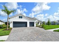 Beautiful single-story home with a three-car garage and a paver driveway and lots of curb appeal at 2469 Paradise Plum Dr, Sarasota, FL 34240
