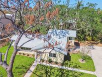 Charming home with a new metal roof, beautiful landscaping, and vibrant green lawn at 3001 Bay Shore Cir, Sarasota, FL 34234