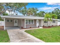 Charming single-story home with a well-manicured lawn, mature trees, and a welcoming walkway at 3153 Irving St, Sarasota, FL 34237