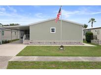 Charming single-story home with tidy lawn, flagpole and covered parking at 3818 Chris Dr, Wesley Chapel, FL 33543