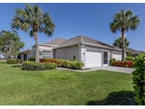Charming single-story home with a two-car garage and tropical landscaping at 4153 Fairway Dr, North Port, FL 34287