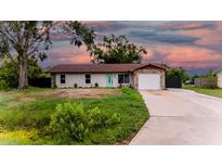 Charming single-story home featuring a stone accent, a teal-colored front door, and an attached garage at 4616 34Th E Ave, Bradenton, FL 34208