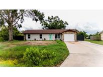 Charming single-story home with stone accents, a well-manicured lawn, and a welcoming turquoise-colored front door at 4616 34Th E Ave, Bradenton, FL 34208