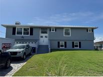 Charming blue two-story home with well-manicured lawn and white trimmed windows at 5111 Bay State Rd, Palmetto, FL 34221