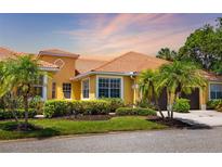 Charming home featuring lush landscaping and a tile roof, complemented by a warm, inviting facade at 5609 Spanish Point Ct, Palmetto, FL 34221