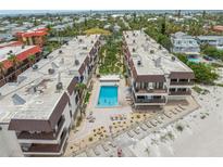 Stunning aerial view of beachfront condos with a sparkling pool and lush landscaping at 5806 Gulf Dr # 201, Holmes Beach, FL 34217