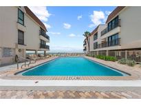 Beautiful beachfront pool and lounge area between condominium buildings at 5806 S Gulf Dr # 201, Holmes Beach, FL 34217