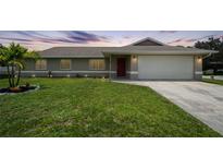Charming single-story home with lush lawn, landscaping, and a two-car garage at 590 Ridgewood Nw St, Port Charlotte, FL 33952